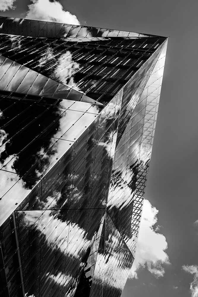 Schwarz‑weiß Glasfassade des 3XN Cube mit Wolkenspiegelungen