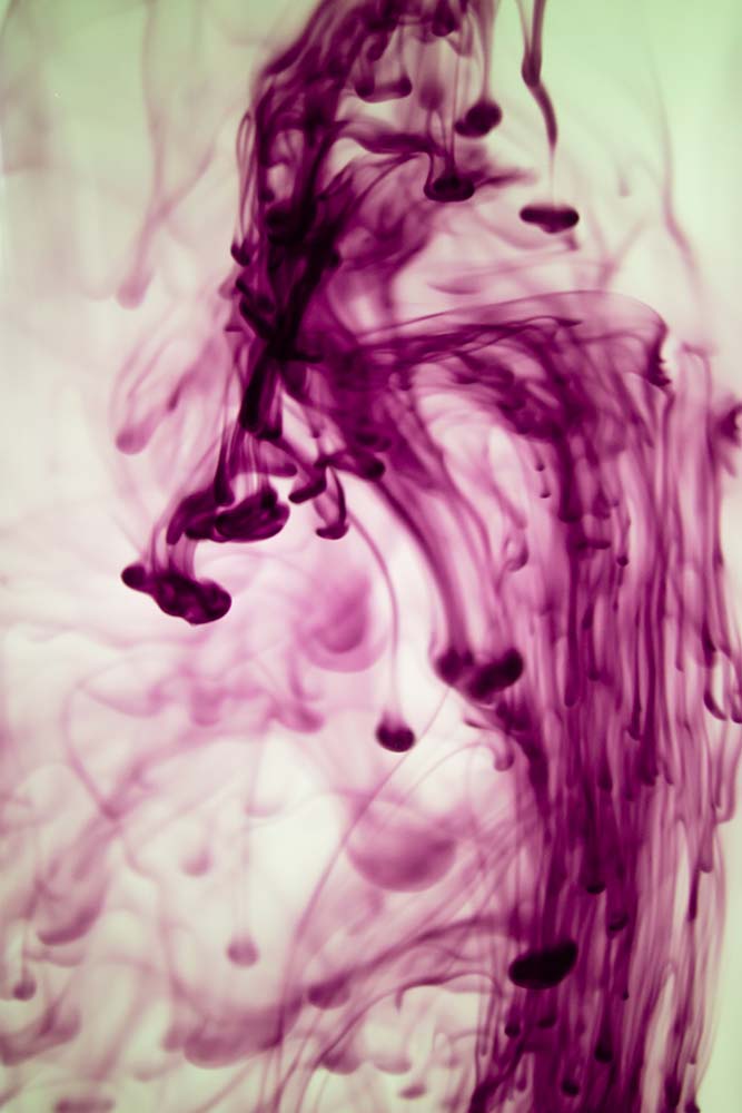 Violette Tinte in Wasser mit fließenden Formen