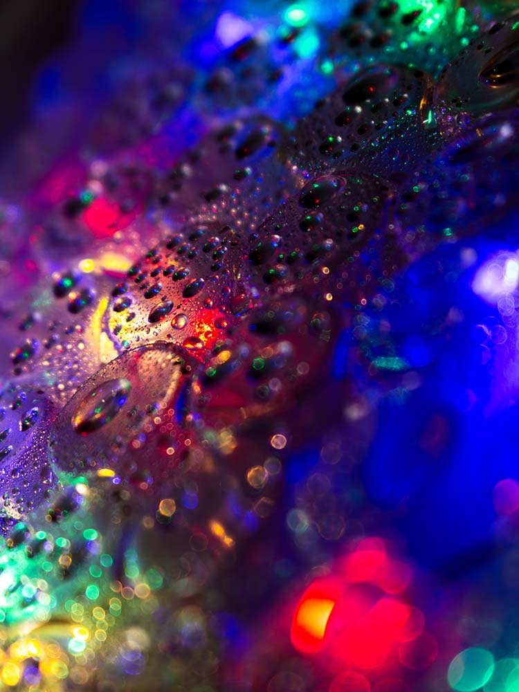 Bunte Wassertropfen auf glänzender Oberfläche in Makroaufnahme