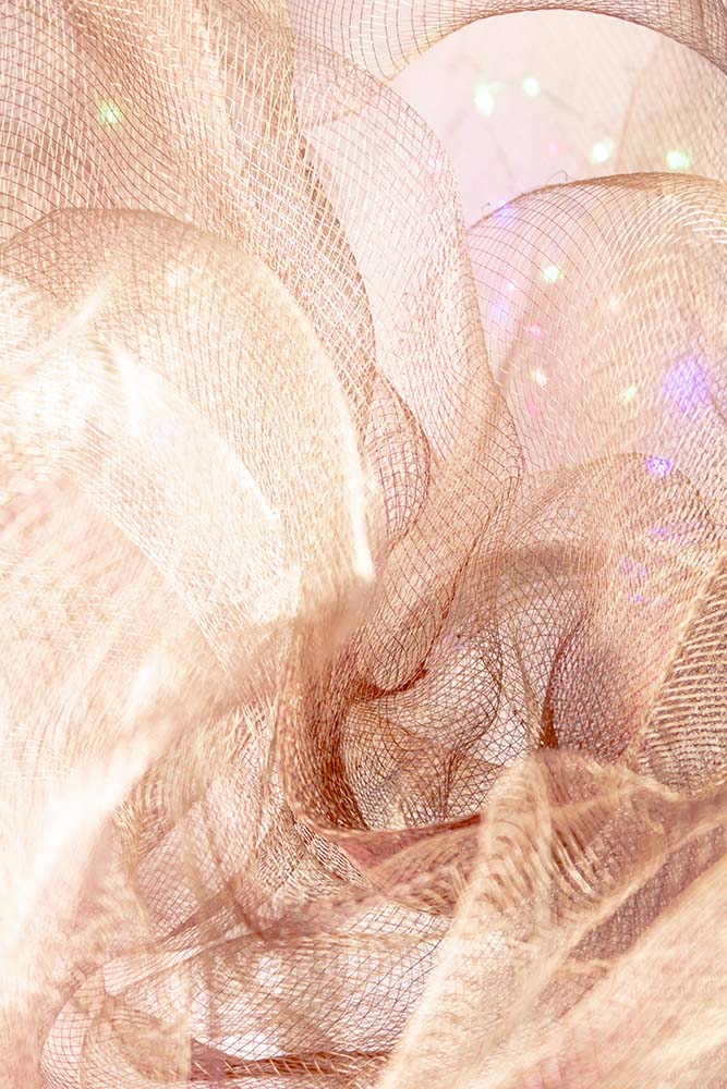 Helles, kupferfarbenes Netzgewebe mit fließenden, schimmernden Strukturen.