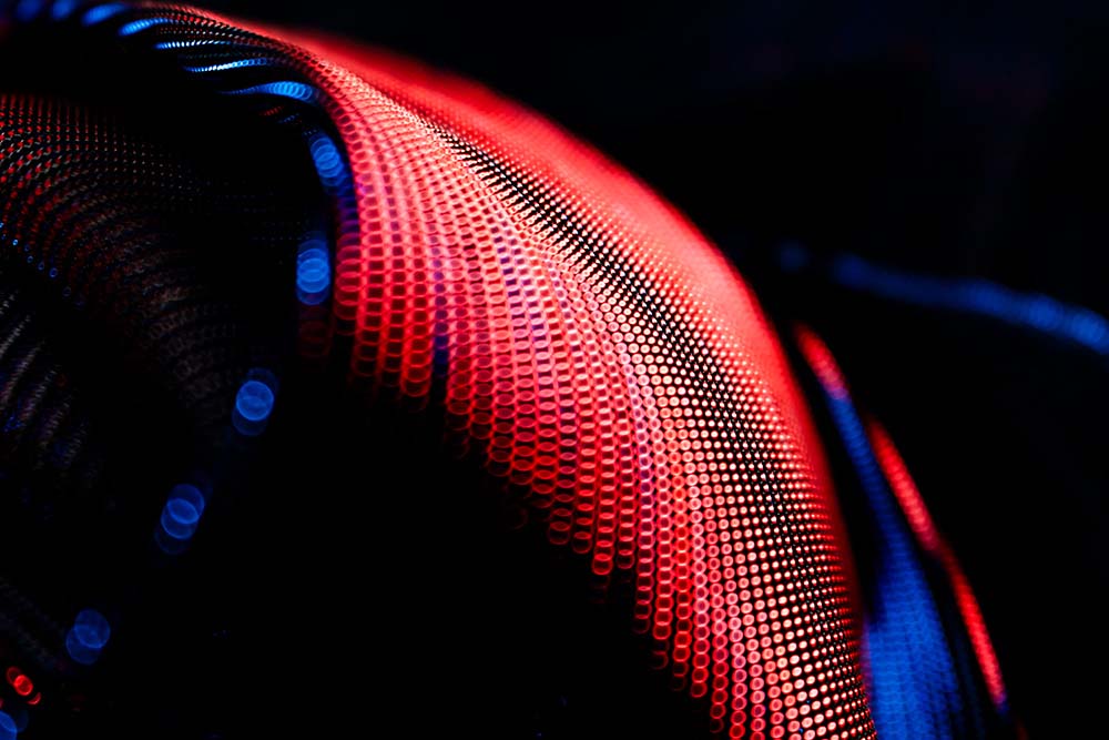 Leuchtende rote und blaue Punktlinien in abstrakten Wellenformen.