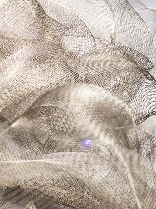Helles, neutrales Netzgewebe in weich fließenden, strukturierten Formen.