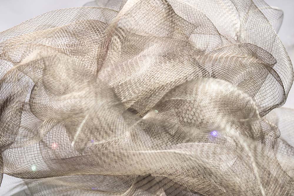 Helles, neutrales Netzgewebe in weich fließenden, strukturierten Formen.