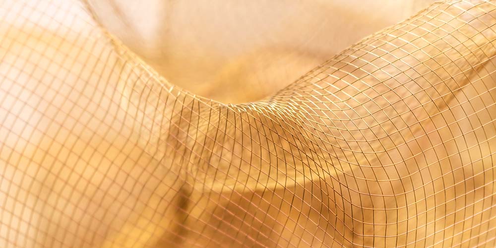 Goldenes, weich fließendes Netzgewebe in sanften Lichtwellen.