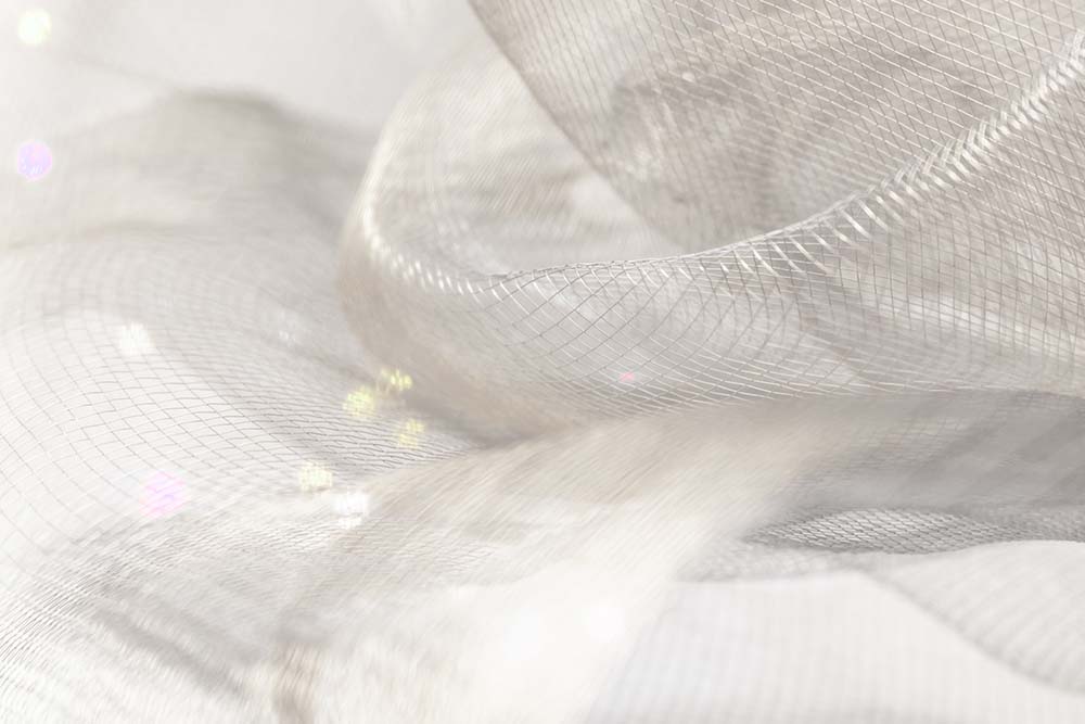 Zartes, helles Netzgewebe in weichen, fließenden Strukturen.