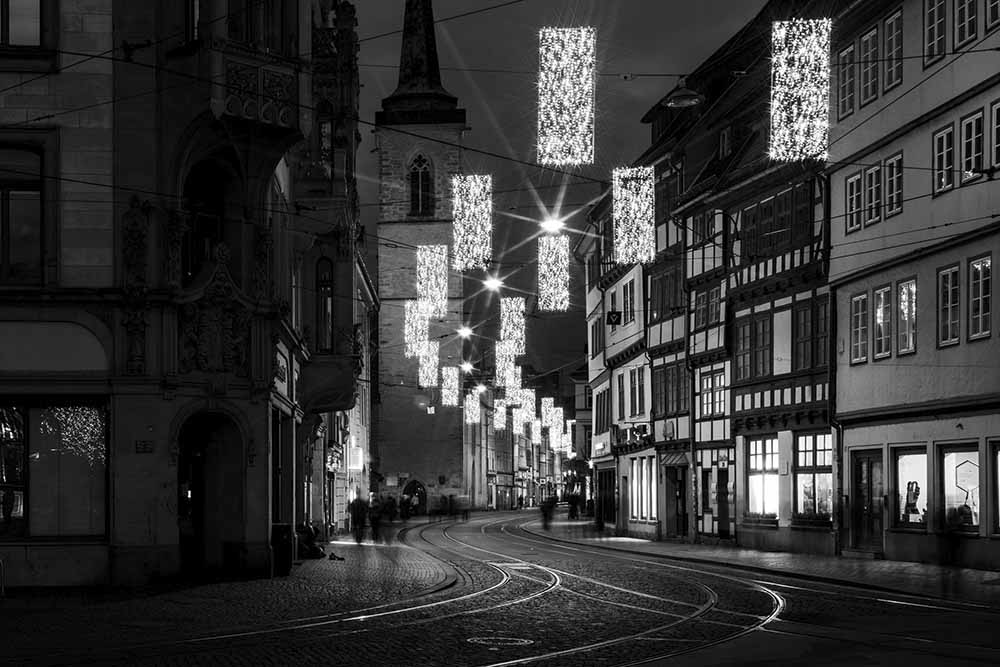 Schwarz‑weiß: Marktstraße Erfurt mit Weihnachtslichtern und Tram‑Gleisen.