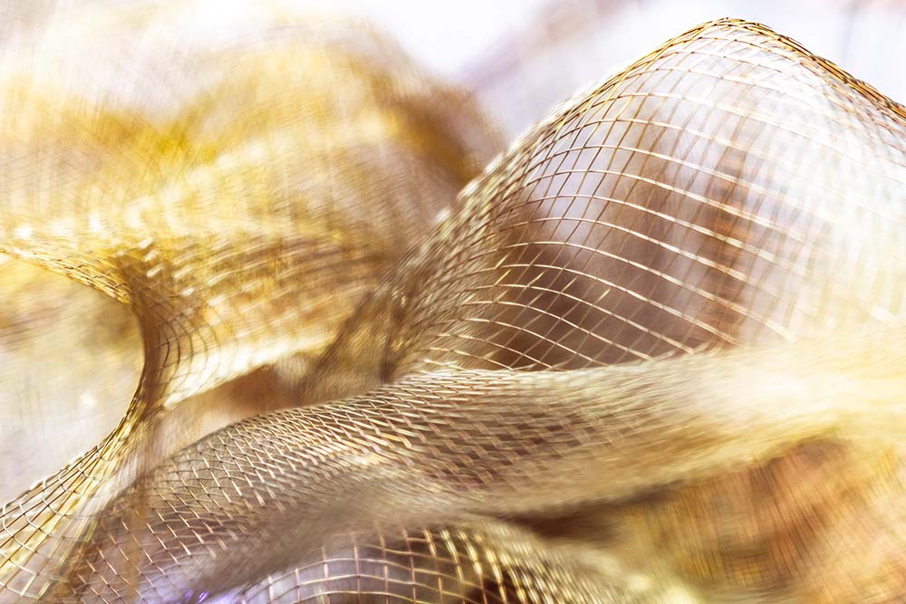 Goldschimmerndes, abstraktes Netzgewebe mit weichen, fließenden Strukturen.