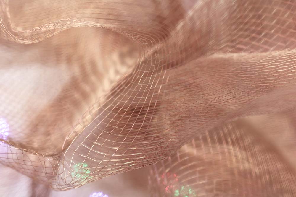 Warm schimmerndes Netzgewebe in weichen, fließenden Strukturen.