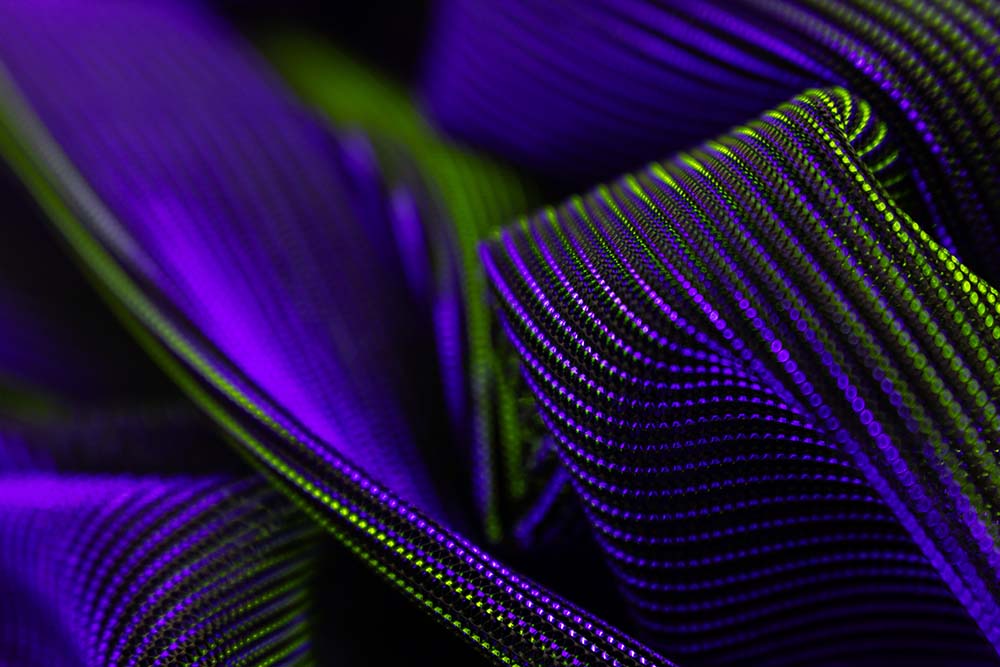 Abstrakte violett‑grüne Linien aus dicht angeordneten Punktmustern.