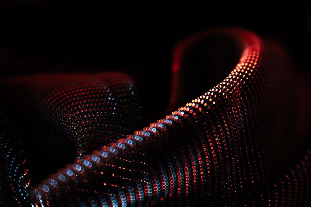 Rote und blaue digitale Punktlinien in geschwungenen Formen.