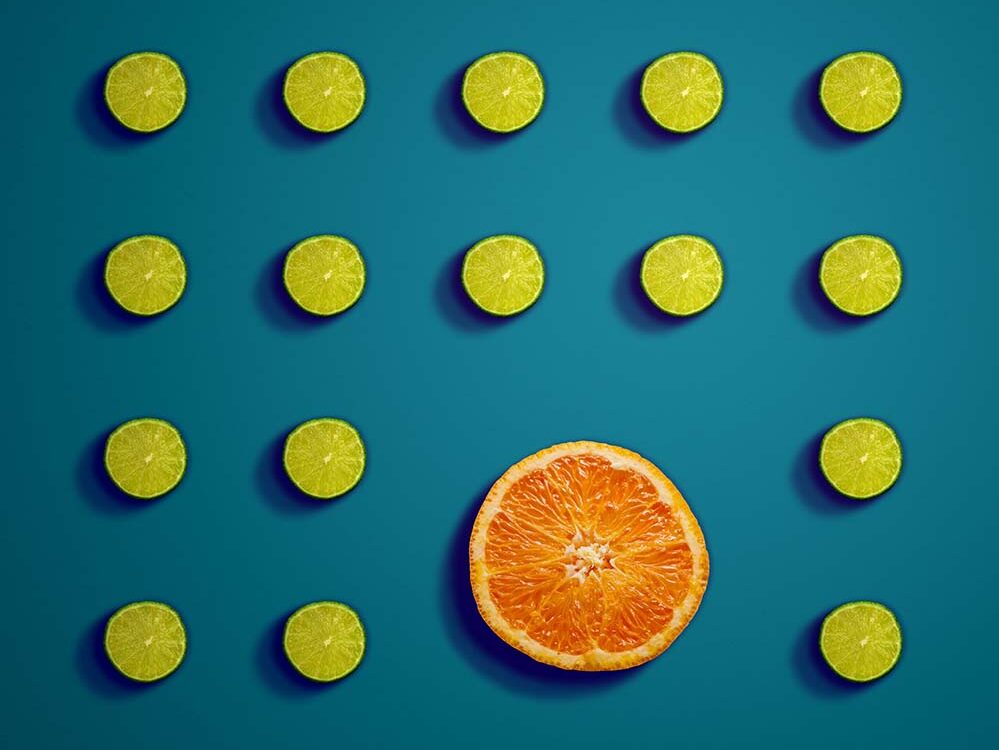 Grapefruit slice surrounded by lime slices in a symmetrical pattern.