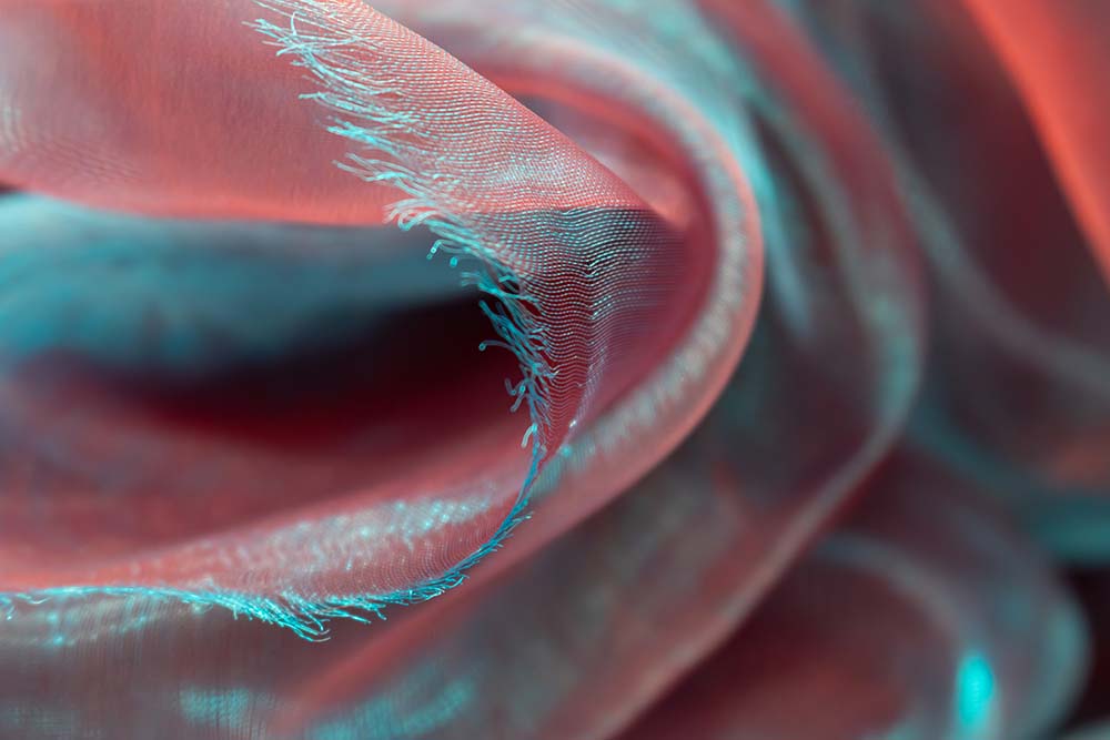 Zarte Organza‑Falten in Blau und Rosé in Makroaufnahme.