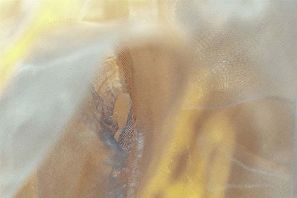 Weiche, warme Stoffschichten mit transluzentem Licht und feinen Strukturen.