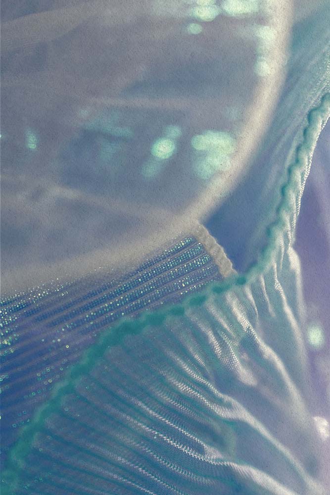 Hellblauer, transparenter Stoff mit feinen Falten und Glanzpunkten.