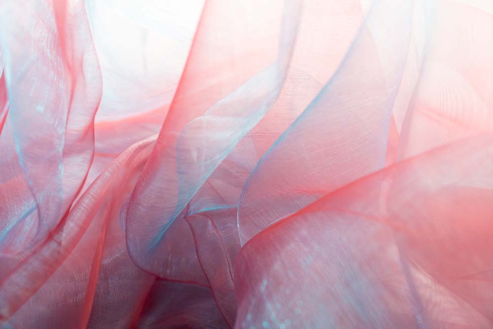 Transparente Organza‑Falten in zarten Blau‑ und Rosétönen.