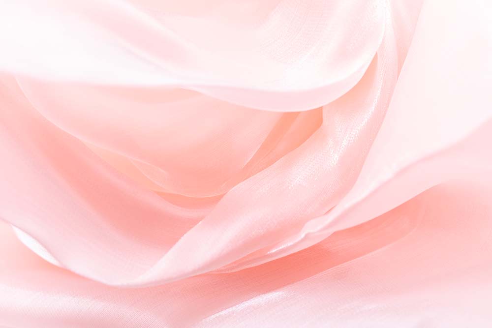 Zarte roséfarbene Stoffschichten in weichen, fließenden Formen.