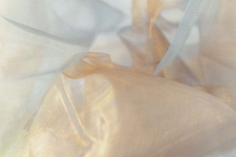 Transluzente Stoffschichten in warmen Creme‑ und Beigetönen.