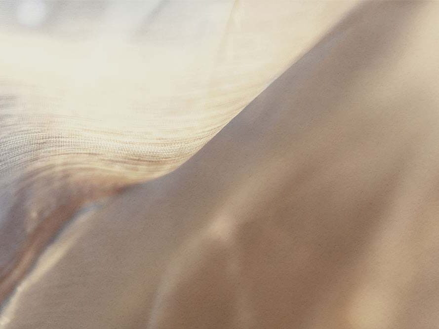 Warm, translucent layers of fabric in gentle, flowing movement.