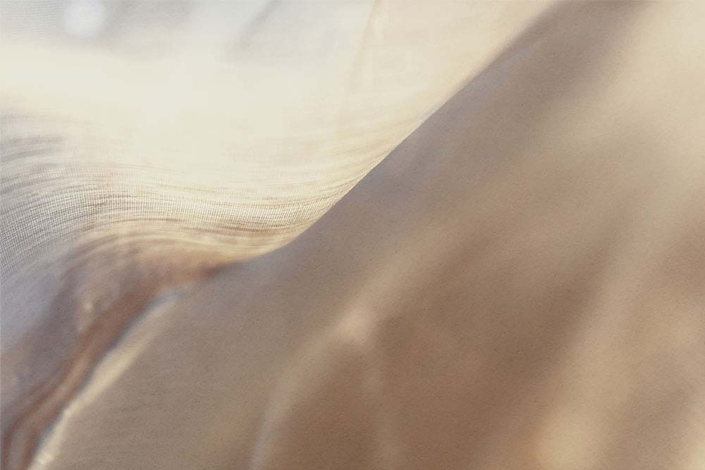 Warme, transluzente Stoffschichten in sanfter, fließender Bewegung.