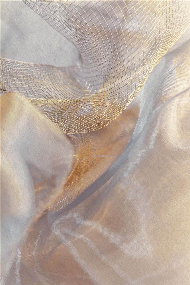 Schimmerndes, fließendes Netz‑ und Stoffgewebe in weicher Bewegung.