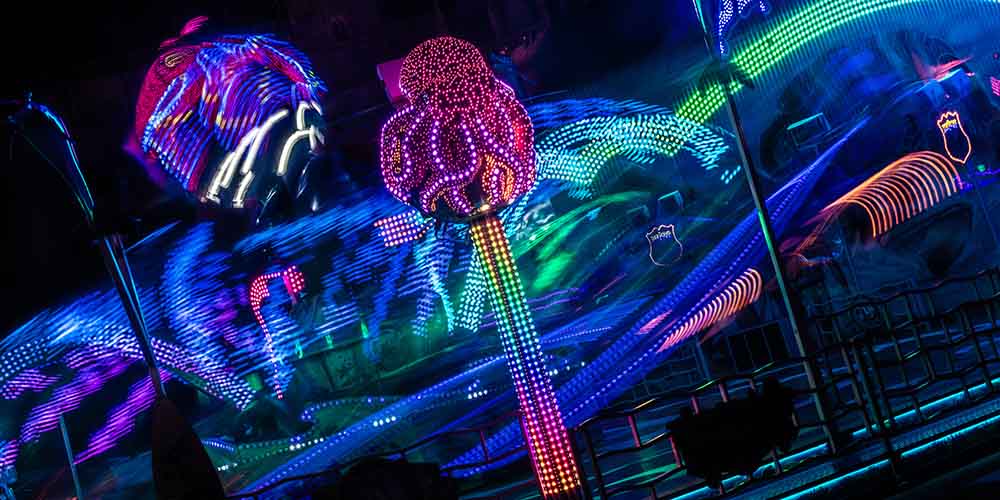 Colorful fairground lights at night with motion blur