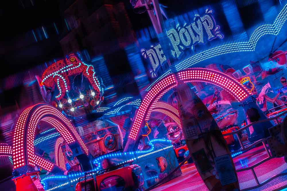 Colorful fairground ride with neon lights at night