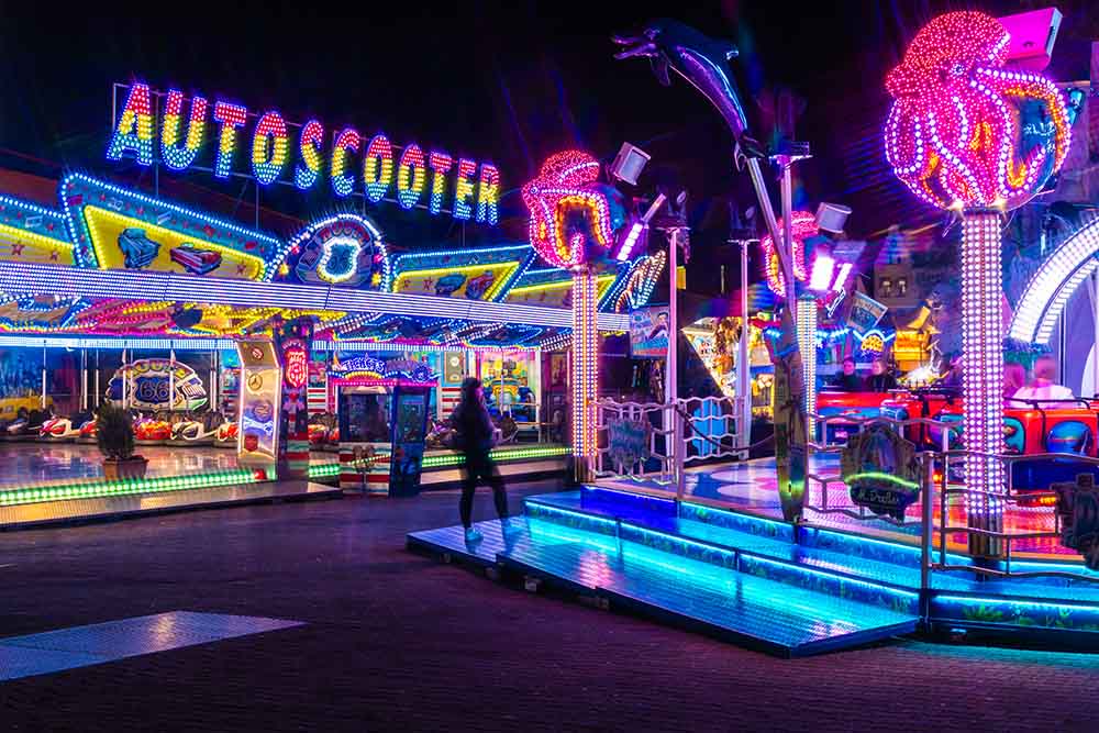 Bunt beleuchteter Autoscooter auf Jahrmarkt bei Nacht